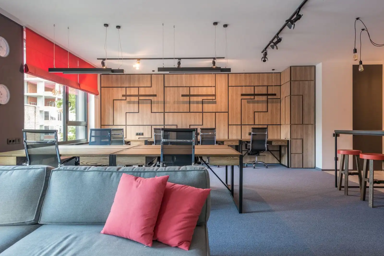 Office floor with timber wall storage, work desks and a lounge sofa