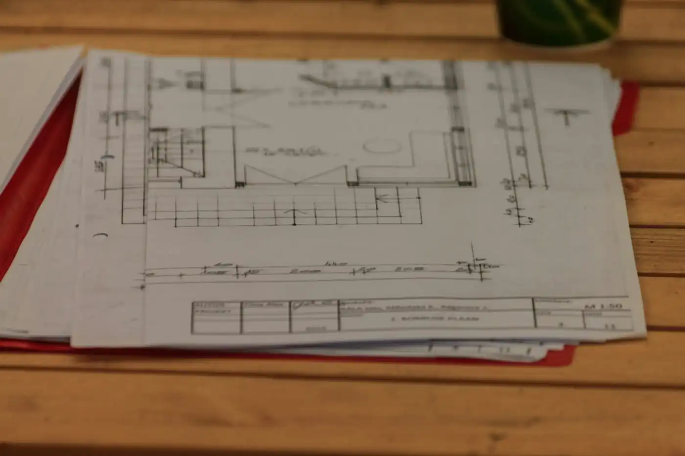 Floor plan drawings of a home spread out on a wooden table